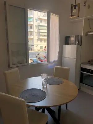 a table and chairs in a kitchen with a window at Le St Lambert, Grand Studio Libération in Nice