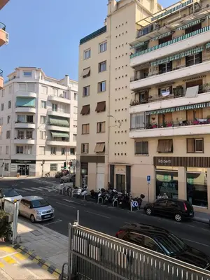 a city street with cars parked in front of tall buildings at Le St Lambert, Grand Studio Libération in Nice
