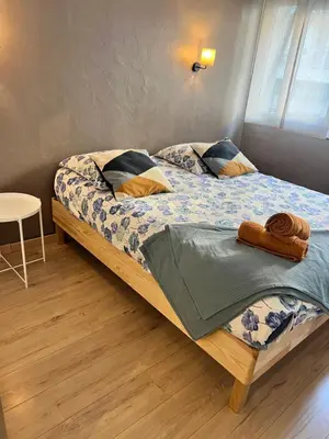 a bedroom with a bed and a table at Bel appartement spacieux avec joli balcon arboré, calme, bien situé, centre ville in Nice