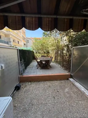 a patio with a table and a bench on a patio at Cosy appartement, terrasse in Nice