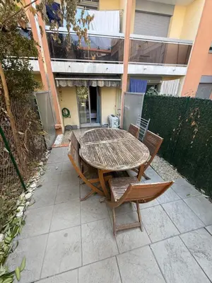 a kitchen with white cabinets and a sink and a chair at Cosy appartement, terrasse in Nice