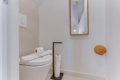 a white bathroom with a toilet and a mirror at AUTHENTIC VILLEFRANCHE AP4472 By Riviera Holiday Homes in Villefranche-sur-Mer