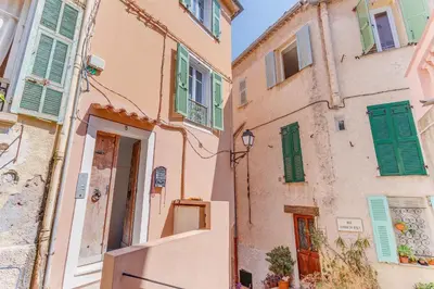 an alley in an old building with green shutters at AUTHENTIC VILLEFRANCHE AP4472 By Riviera Holiday Homes in Villefranche-sur-Mer