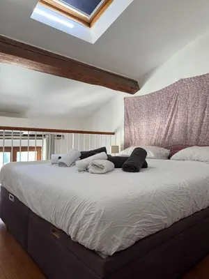 a large bed with white sheets and pillows on it at Antibes Centre 2 pièces cosy proche remparts in Nice