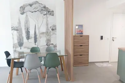 a dining room with a table and four chairs at Seafront apartment with pool and comfort in Saint-Laurent-du-Var