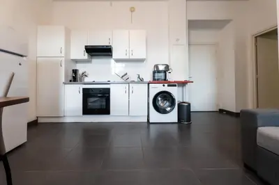 a kitchen with a washing machine in a room at Le Malausséna in Nice