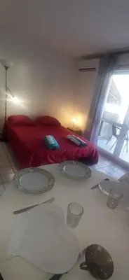 a bedroom with a red bed with four plates on the floor at Studio climatisation balcon à 5 min de la plage in Nice