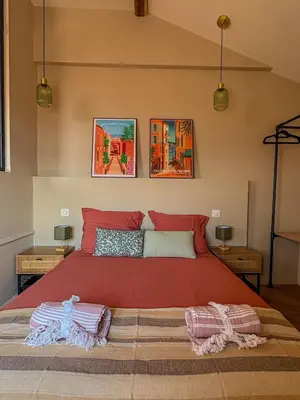 a bedroom with a large red bed with two pillows at Charmant 2 pièces rénové avec vue mer in Villefranche-sur-Mer