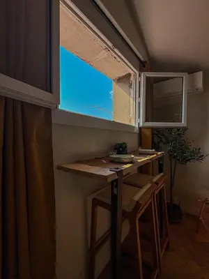 a small kitchen with a table and a window at Charmant 2 pièces rénové avec vue mer in Villefranche-sur-Mer