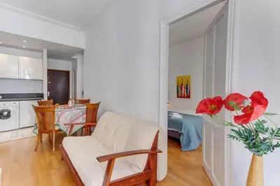 a living room with a white couch and a vase with red flowers at LE CONCORDIA AP4478 by RIVIERA HOLIDAY HOMES in Nice