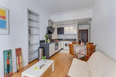 a living room with a white couch and a kitchen at LE CONCORDIA AP4478 by RIVIERA HOLIDAY HOMES in Nice