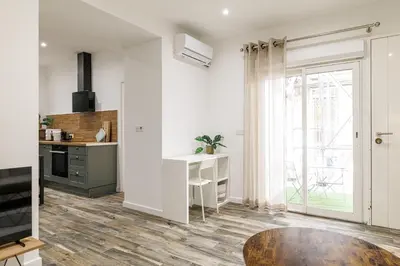 a kitchen with white walls and a wooden floor at Ultra Central Rue Massena 1 Bdr in Nice