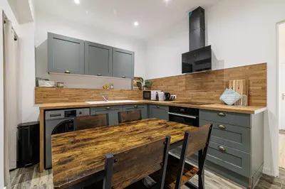 a kitchen with a wooden counter top and a table at Ultra Central Rue Massena 1 Bdr in Nice
