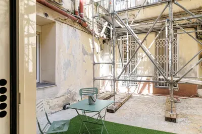a table and a chair in a room with scaffolding at Ultra Central Rue Massena 1 Bdr in Nice