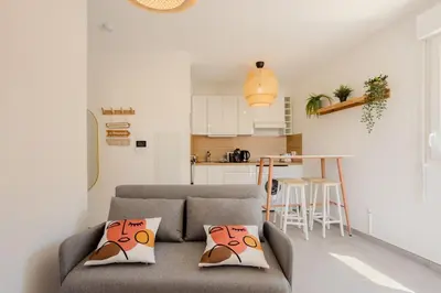 a living room with a couch and a kitchen at Nice 2 pièces charmant proche port et transports in Nice