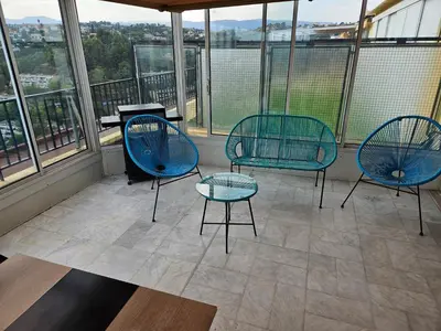 three chairs and a table in a room with windows at Logement vue mer - Nice ouest in Nice
