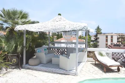 a gazebo with chairs and an umbrella on a patio at Villa le Mazet, Nice, piscine, vue mer, Promenade des Anglais, Baie des Anges in Nice
