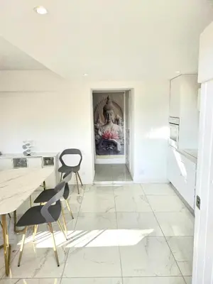 a white kitchen with a table and chairs at Villa le Mazet, Nice, piscine, vue mer, Promenade des Anglais, Baie des Anges in Nice