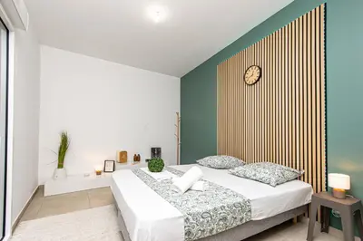 a bedroom with a bed with a clock on the wall at Appartement neuf - Patio intérieur - Parking - EF in Èze