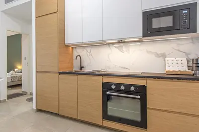 a kitchen with a stove and a microwave at Appartement neuf - Patio intérieur - Parking - EF in Èze