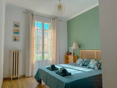 a bedroom with a bed and a large window at Close to sea center apartment 130m2 in Nice