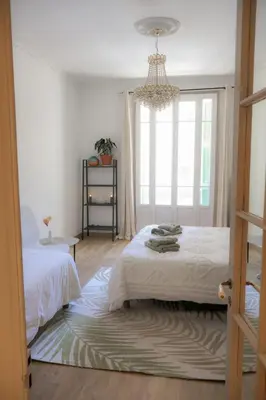 a bedroom with a bed and a chandelier at Close to sea center apartment 130m2 in Nice