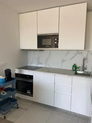 a kitchen with white cabinets and a microwave at New flat with swimming pool on rooftop in Saint-Laurent-du-Var