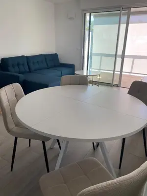 a white table and chairs in a room with a couch at New flat with swimming pool on rooftop in Saint-Laurent-du-Var