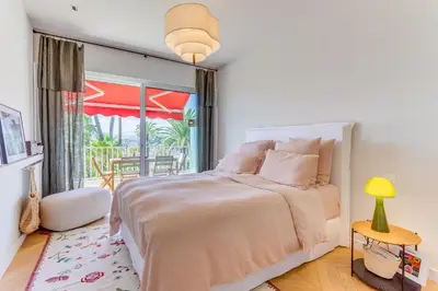 a bedroom with a bed and a large window at MONT BORON PALMS AP4480 by Riviera Holiday Homes in Nice