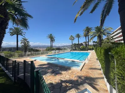 a swimming pool with palm trees in the background at MONT BORON PALMS AP4480 by Riviera Holiday Homes in Nice