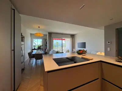 a kitchen and living room with a sink and a table at MONT BORON PALMS AP4480 by Riviera Holiday Homes in Nice
