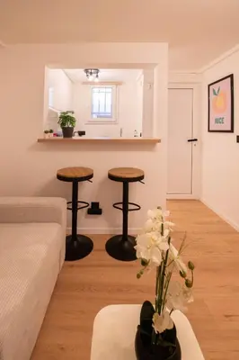 a living room with two tables and two stools at Studio Place Masséna in Nice