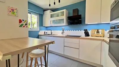 a kitchen with white cabinets and a wooden counter top at L'Éclat d'Azur in Nice