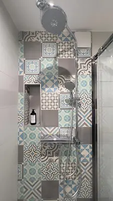 a bathroom with a shower with a tiled wall at L'Éclat d'Azur in Nice