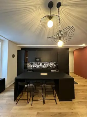 a dining room with a black table and a kitchen at Heart of Nice Beautiful apartment 3 bedrooms in Nice