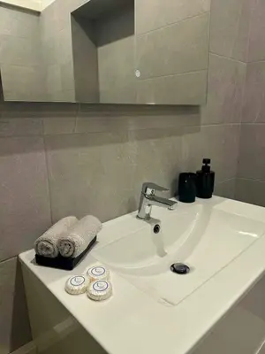 a white bathroom sink with a mirror and towels at Heart of Nice Beautiful apartment 3 bedrooms in Nice