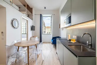 a kitchen with a table and chairs in a room at Residence Garibaldi - Nice in Nice