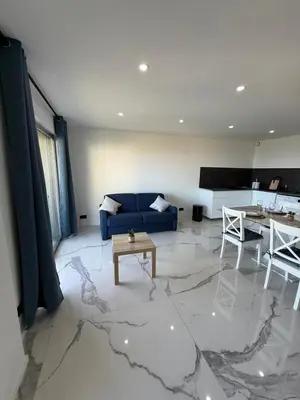 a living room with a blue couch and a table at Sea View, Modern Apartment and Terrace in Nice