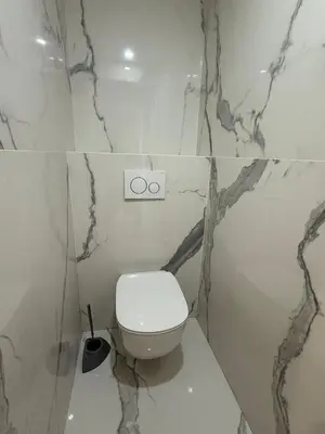 a bathroom with a white toilet and marble walls at Sea View, Modern Apartment and Terrace in Nice