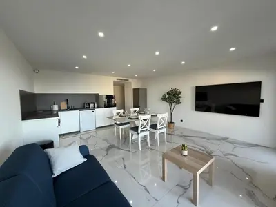 a living room with a blue couch and a table at Sea View, Modern Apartment and Terrace in Nice
