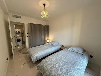 a bedroom with two beds and a light fixture at Sea View, Modern Apartment and Terrace in Nice