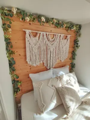 a bed with a wooden headboard with flowers on it at Studio Jungle Bohème - à 3 min de la Promenade des anglais à pieds in Nice