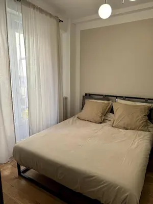 a bed with white sheets and pillows in a bedroom at Carré d'Or - 2P Cosy avec Terrasse et véranda in Nice