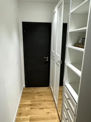 a hallway with a black door and white shelves at Carré d'Or - 2P Cosy avec Terrasse et véranda in Nice