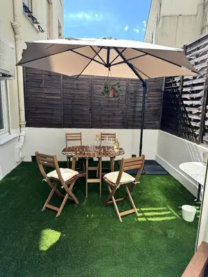 a patio with a table and chairs and an umbrella at Carré d'Or - 2P Cosy avec Terrasse et véranda in Nice