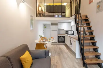 a small living room with a couch and a staircase at Duplex cosy dans la Vieille Ville in Nice