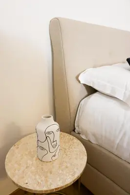 a vase sitting on a table next to a bed at Carre d'OR Massena luxury apartment in Nice