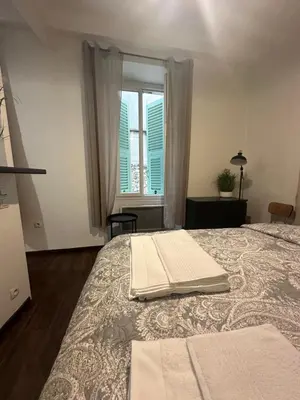 a bedroom with a large bed with a window at Studio Rue Bonaparte in Nice