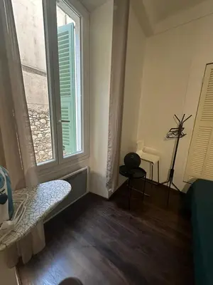 a room with a bed and a window and a table at Studio Rue Bonaparte in Nice