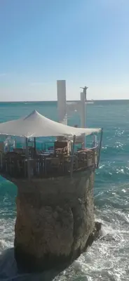 a restaurant on top of a rock in the ocean at Studio Rue Bonaparte in Nice
